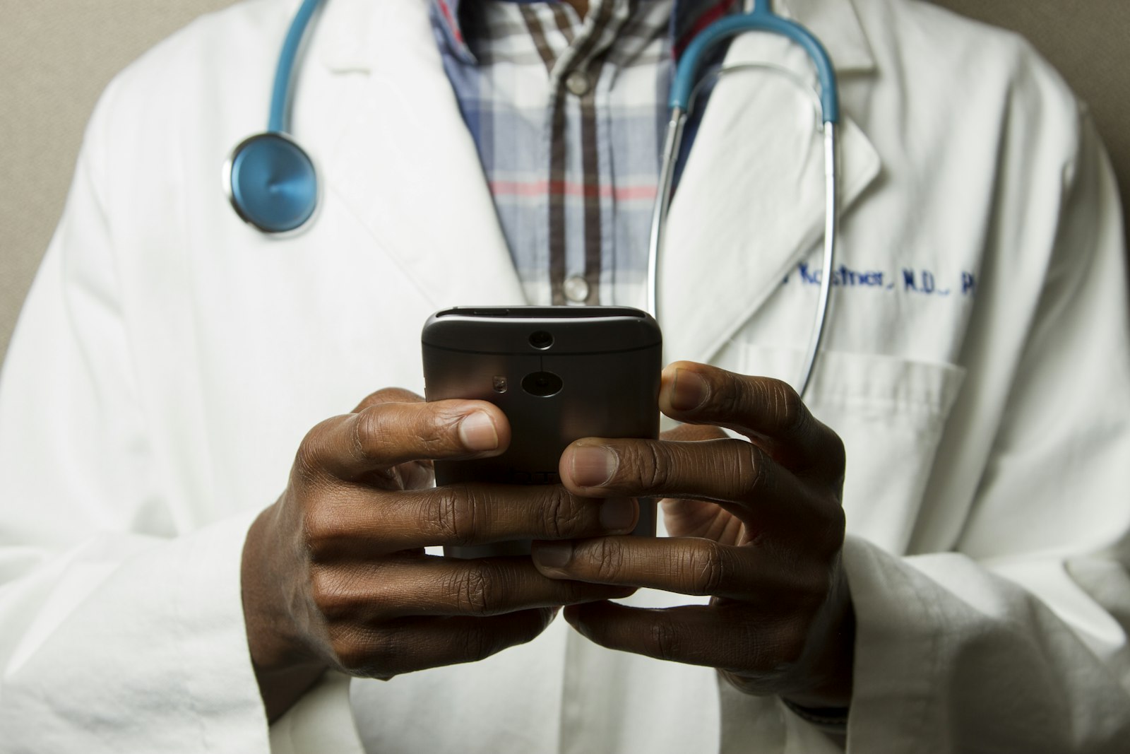 Clinician holding a smartphone, stethoscope around the neck
